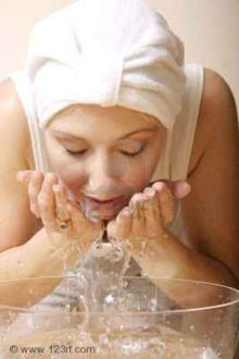 233520-skin-fresh-a-woman-cleanses-her-face-hands-cupping-fresh-water-over-a-bowl-some-motion